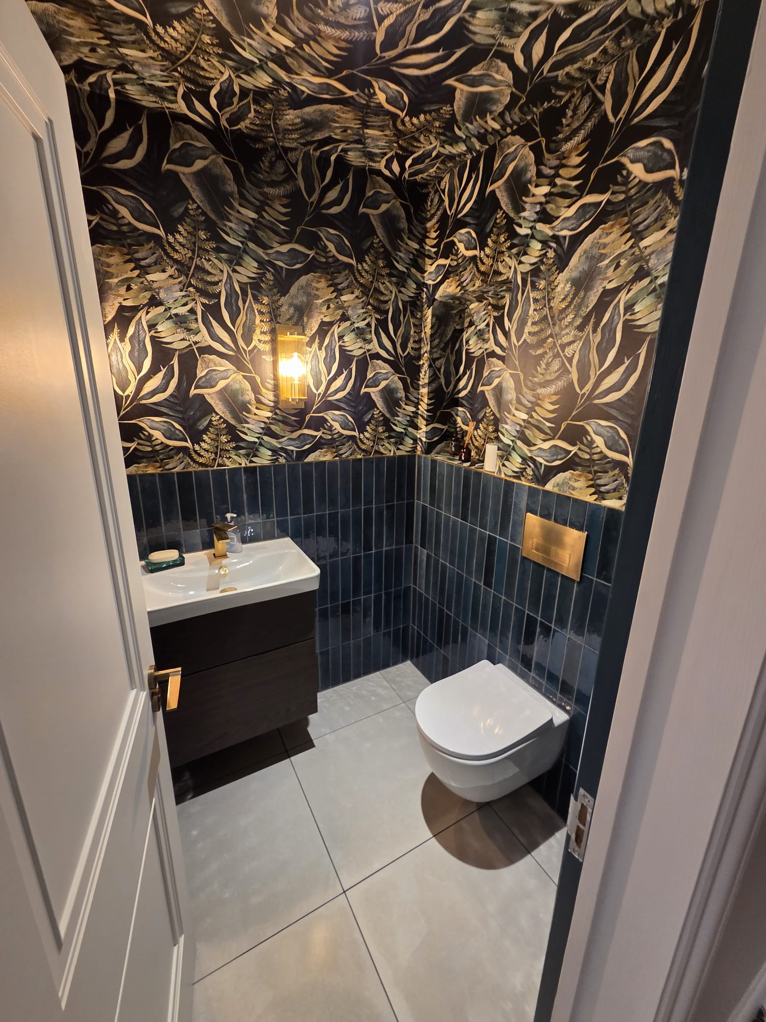 Luxury bathroom with botanical wallpaper and teal tiles